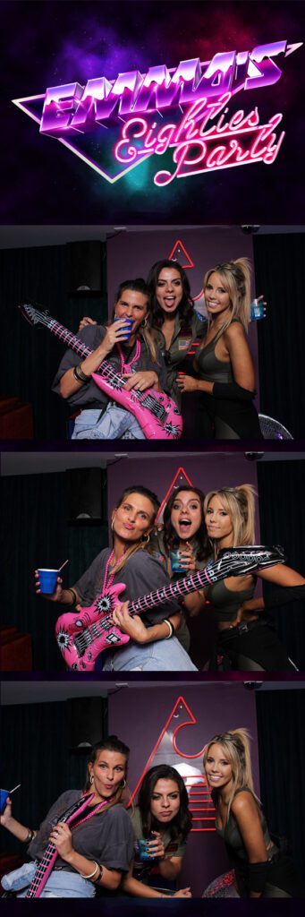 Guests smiling brightly while posing at the Open Air Photo Booth.