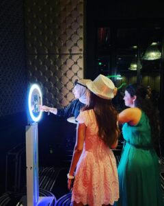 Guests enjoying an open-air photo booth at a wedding.